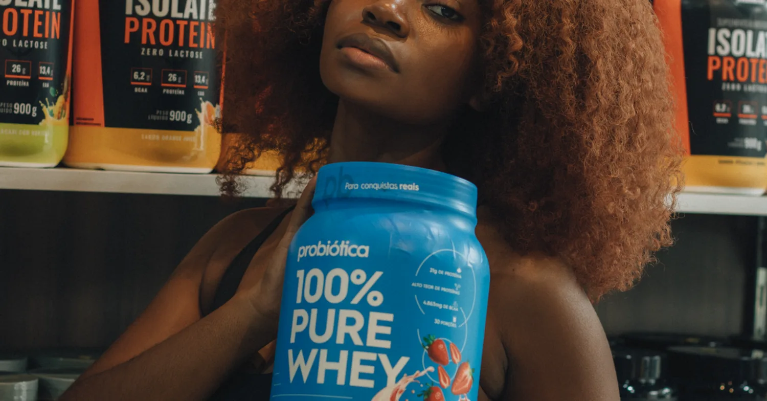 Blerëse duke zgjedhur proteinë whey në dyqan suplementesh